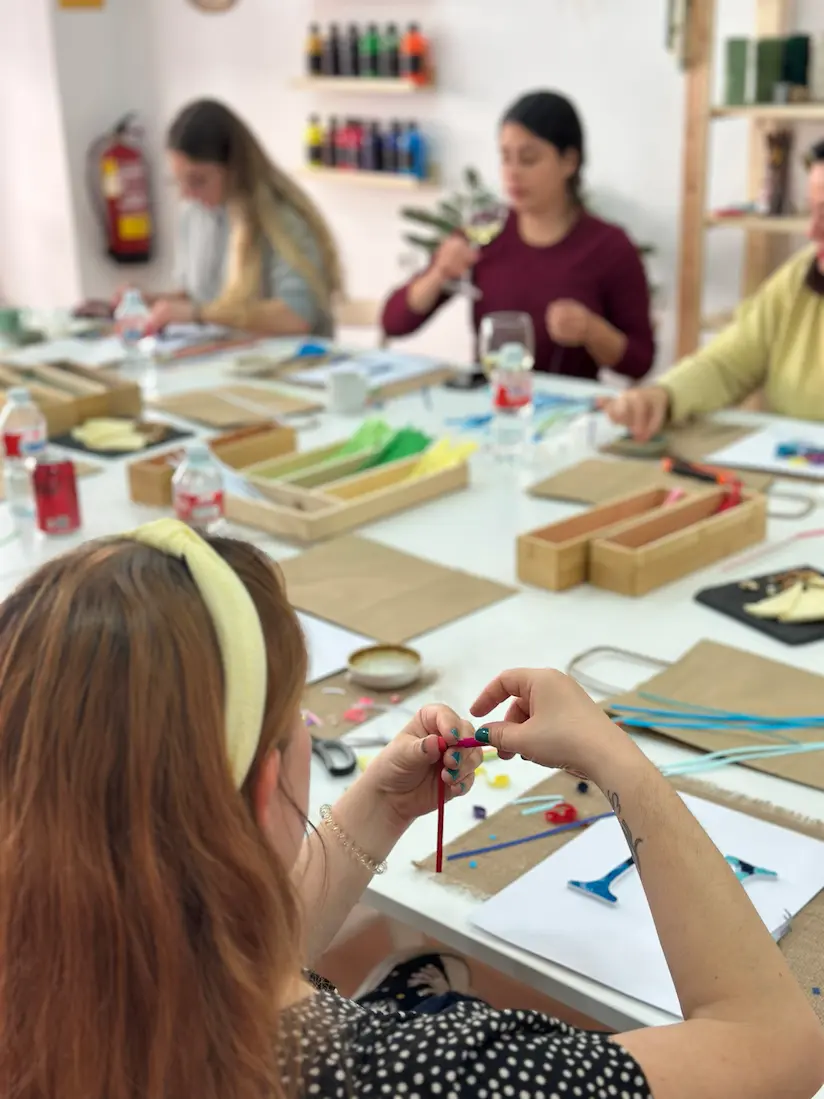 mujer enrollando papel en un taller de letras de quilling para adultos