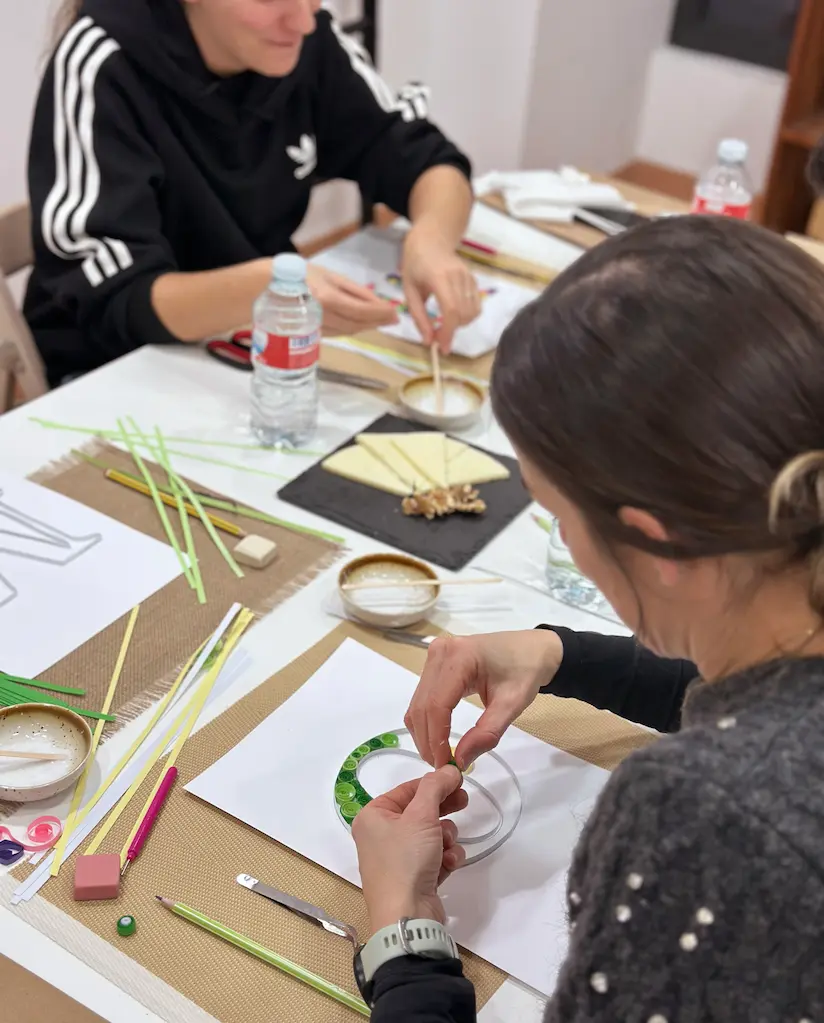 mujer rellenando una letra con la técnica de quilling en el taller de quilling de Alcalá de Henares