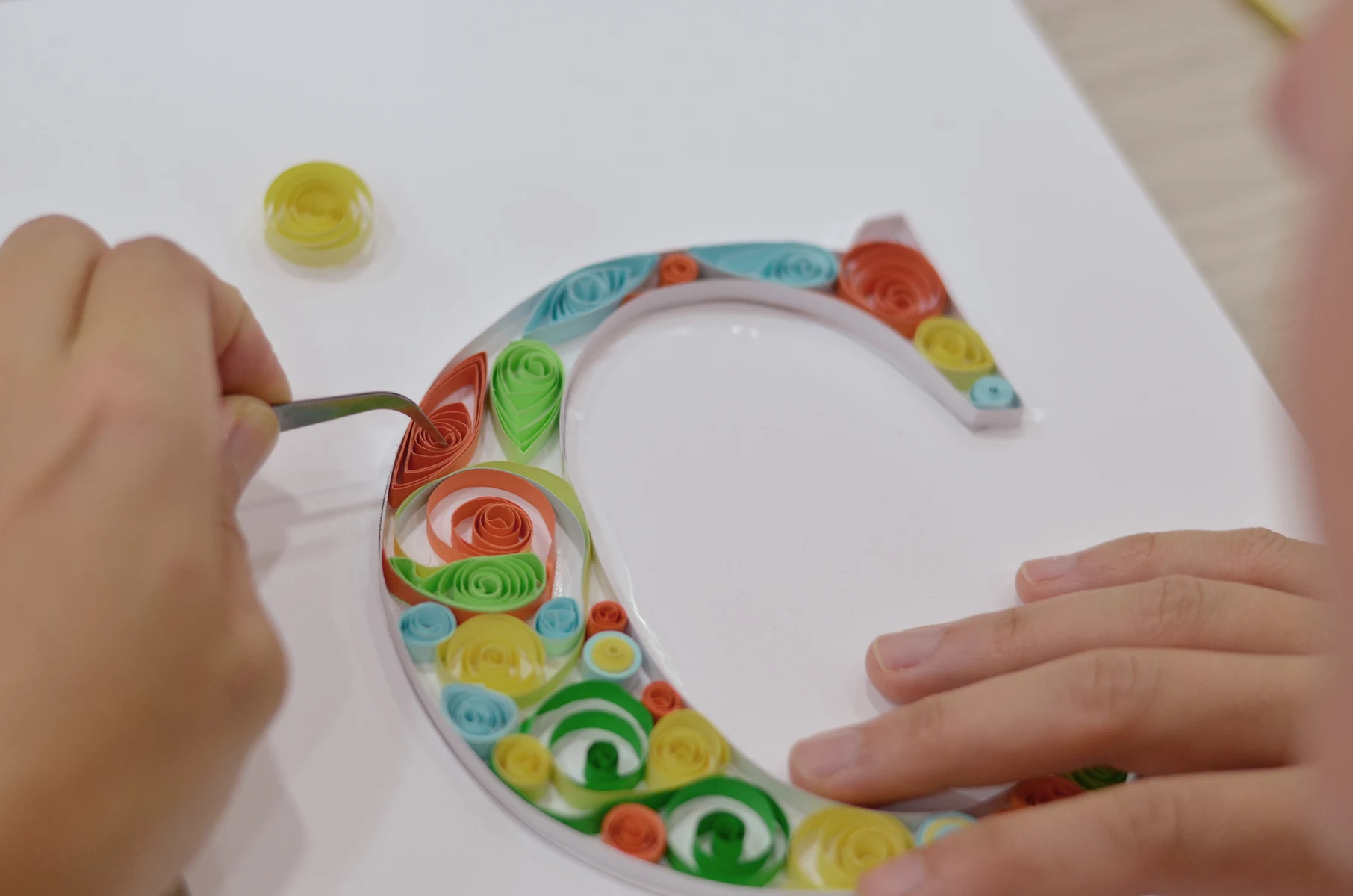 Participante colocando los materiales del taller de Quilling