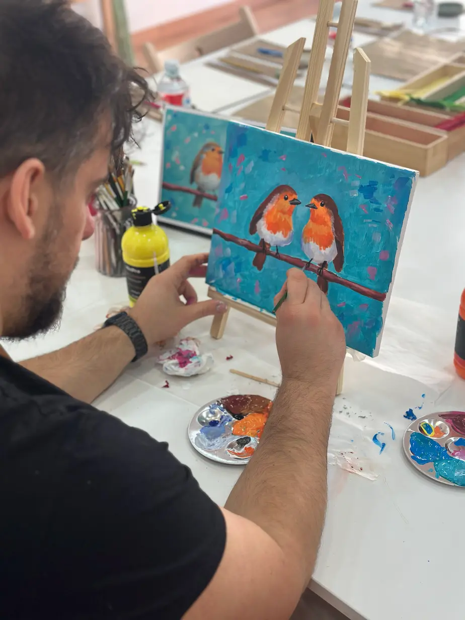 hombre pintando un cuadro con pintura acrílica